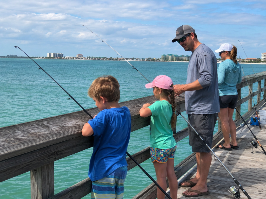 Family fishing together from a pier on the Florida Gulf Coast.